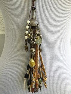 Pearl Strand with Multi Tassel. Hand crafted by Amy Kaplan. Amy is a truly talented artisan who has been hand crafting high quality custom jewelry for cowgirls with discriminating taste. You'll have a unique custom piece of western jewelry that stands out from the crowd. Glass pearl strand, multi tassel, pewter and Indian silver plated brass beads, horn and bone accents. Artisan Brown Jewelry With Tassels, Brown Tassel Jewelry For Festivals, Bohemian Brown Jewelry With Latkans, Brown Fringe Jewelry For Festivals, Bohemian Lariat Jewelry With Fringe, Unique Tassel Jewelry For Festivals, Bohemian Lariat Jewelry For Western-themed Events, Bohemian Brown Tassel Jewelry, Handmade Western Jewelry For Festival