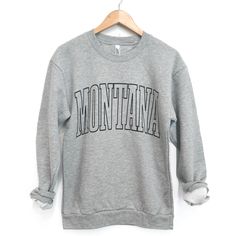 Montana Unisex Pullover - Heather Grey - The Montana Scene Gray Fall Sweater For College, Gray Graphic Print Sweater For Loungewear, Gray Varsity Sweatshirt With Graphic Print, Gray Letter Print Sweatshirt For College, College Heather Grey Tops With Letter Print, Heather Grey Letter Print Top For College, Trendy Gray Sweater With Letter Print, Gray College Style Sweatshirt For Fall, Gray College-style Top With Letter Print