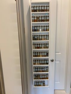 the pantry door is open and there are many jars in it