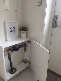 a white shelf with pipes and a sign on it