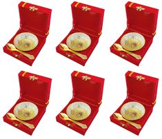 six red velvet boxes with gold plates and spoons in them, all lined up on top of each other