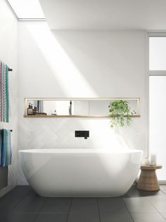 a white bath tub sitting on top of a tiled floor