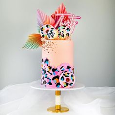 a pink and blue decorated cake on top of a white table