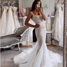 a woman taking a selfie in front of a mirror while wearing a wedding dress