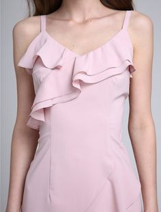 a woman wearing a pink dress with ruffles on it