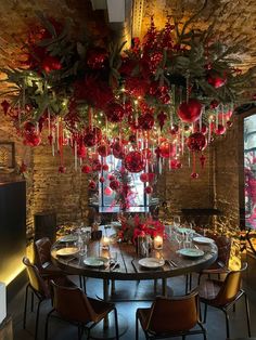 a dining room table with christmas decorations hanging from the ceiling and candles lit up in front of it