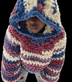 a young child wearing a crocheted hooded jacket