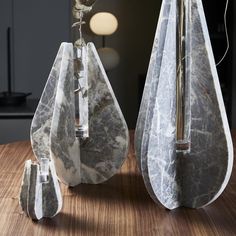 two marble vases sitting on top of a wooden table