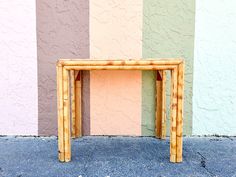 a small wooden table sitting in front of a colorful wall