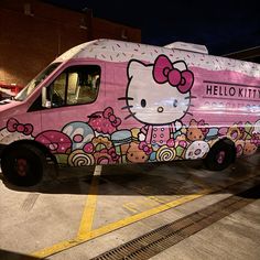 a pink van with hello kitty painted on it's side parked in a parking lot