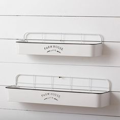 two white wall mounted shelves with farm house labels on the top one and bottom one