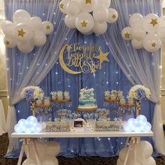 a blue and white dessert table with balloons