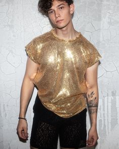 Elevate your fashion game with our Men's Gold Sequin Shirt. This stunning piece is designed to make you shine on any occasion. Whether it's a special event or a night out, this shirt will turn heads and leave a lasting impression. Its high-quality sequin fabric is comfortable and eye-catching, ensuring you stand out from the crowd. Available in various sizes to suit your fit. Order yours now and be the center of attention! Shiny Outfits Men, Mens Gold Outfit, Gold Party Outfit Men, Black And Gold Male Outfits, Mens Sparkle Outfit, Reputation Era Outfits Men, Golden Outfit Men, Sequin Short Sleeve Party T-shirt, Shiny Summer Tops For Night Out