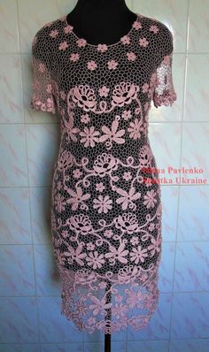 a black and pink dress is on a mannequin head stand in front of a tiled wall