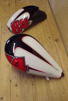 two black and white helmets sitting on top of a wooden floor