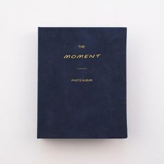 a blue book with the word moment written in gold on it's front cover