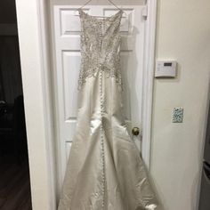 a wedding dress hanging on a door