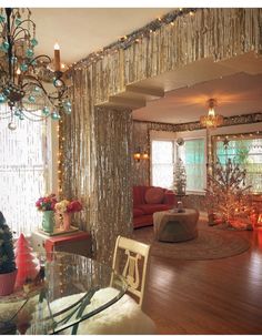 the living room is decorated for christmas with lights and decorations on the walls, along with a chandelier