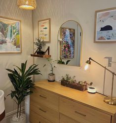 a bathroom with two plants on the counter and one plant in front of the mirror