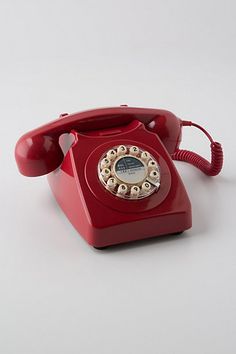 an old fashioned red telephone on a white background