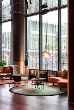 a large living room filled with lots of furniture and tall windowed windows next to each other