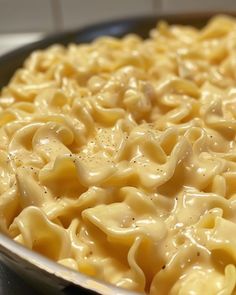 a pan filled with macaroni and cheese on top of a stove