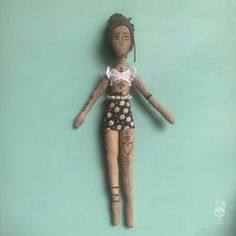 a doll is hanging on the wall in front of a blue background with an image of a woman's body