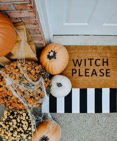 pumpkins and gourds are sitting on the front door mat that says witch please