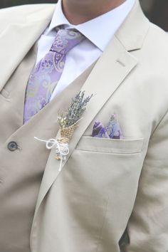 a man wearing a suit and tie with a boutonniere on his lapel