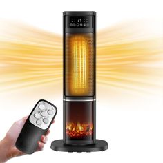 a person holding a remote control next to an electric heater with flames in the background