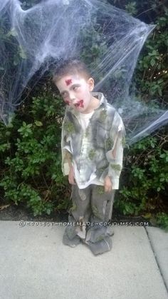 a young boy dressed up as a spider with his face painted red and covered in plastic