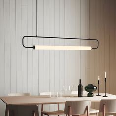 a dining room table with chairs and a long light fixture hanging from it's ceiling