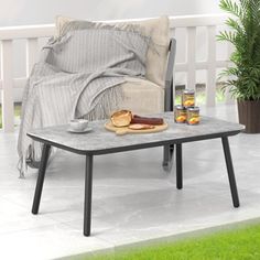 a table that has food on top of it next to a chair and potted plant