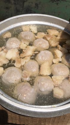 some food is cooking in a pot on the stove and it looks like meatballs