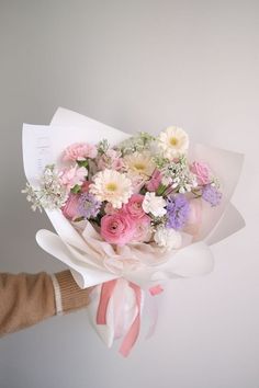 a person holding a bouquet of flowers in their hand