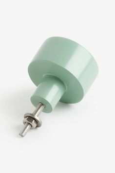 a light green knob with a screw in the middle on a white background, there is no image here to provide a caption for