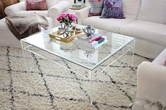 a living room filled with white furniture and lots of pillows