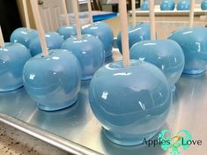 there are many blue candy apples on the table with toothpicks sticking out of them