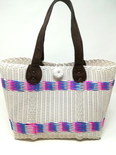 Handwoven by local artisans in Guatemala and designed by Verapaz, this tote bag is crafted from 100% recycled plastic. This colourful, practical and original tote bag is ideal for a visit to the beach, for your iPad or yoga clothes. It is a roomy essential accessory that would add a stylish touch to your outfit. Thanks to the nature and quality of the plastic it has been woven from, this tote is extremely durable and versatile. Height: 24cm Width: 37cm Depth: 15cm Handles drop: 20cm *Since our b Casual White Handwoven Beach Bag, Eco-friendly White Straw Bag With Handles, Eco-friendly White Beach Bag For Market, White Handwoven Beach Bag For Travel, Casual Beach Bag Made From Recycled Materials, White Bucket Beach Bag For Market, Casual White Beach Bag With Leather Handles, White Basket Beach Bag For Everyday Use, White Tote Beach Bag For Market