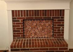 a brick fireplace with logs stacked on top