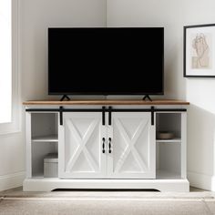 a flat screen tv sitting on top of a white entertainment center