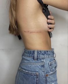 the back of a woman's stomach with writing on her left side, and an arrow