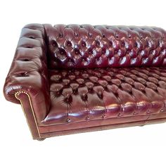 a red leather couch sitting on top of a white floor