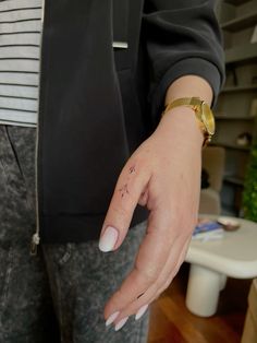 a woman's hand with a small tattoo on it