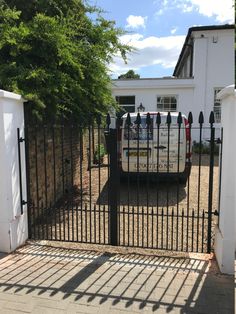 an iron gate is open to the front yard