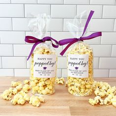 two jars filled with popcorn sitting on top of a wooden table