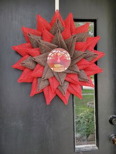 a red and brown wreath on the front door