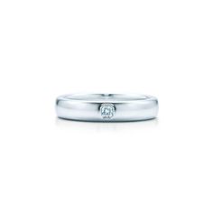 a white gold wedding band with a single diamond in the center and two diamonds on each side