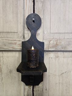 a candle that is sitting on top of a shelf in front of a wooden door