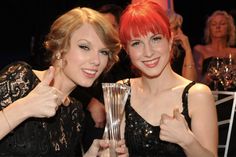 two beautiful young women posing for the camera with an award in front of their faces